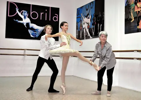 Balerina na špic patikama u sali, Dobrila Novkov ispravlja položaj, na zidu plakat sa njenim imenom